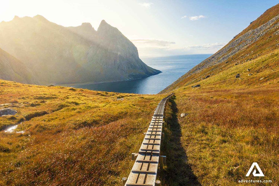 narrow wooden path leading to kvalvika beach in norway