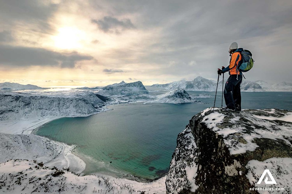 hiker looking over mountains in winter near lofoten