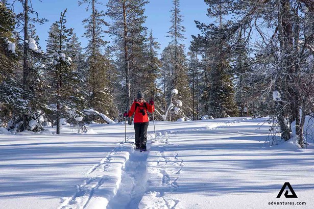 woman hiking with snowshoes in winter in finland
