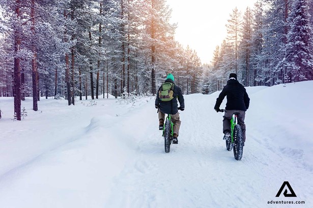 two friends fatbiking in a forest in finland