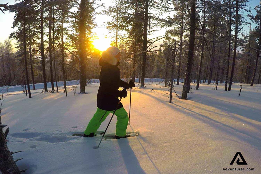 woman snowshoeing at sunset