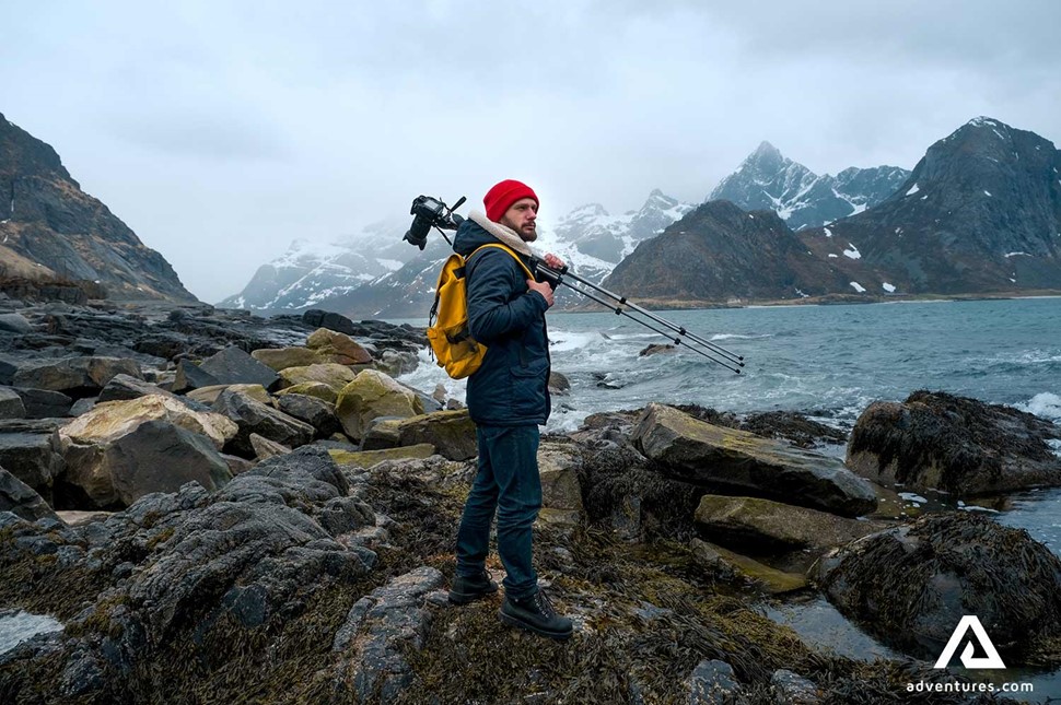 photographer with a tripod near mountains in norway