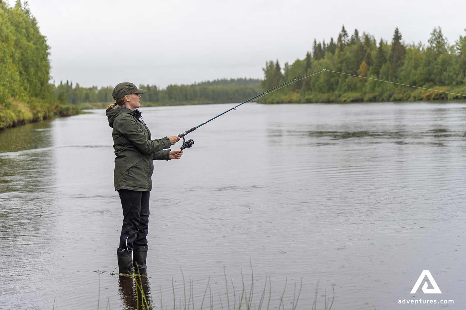 fisher woman with rubber boots in a lake in finland