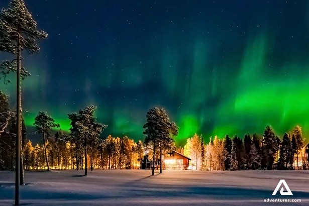 bright northern lights near a town in the countryside