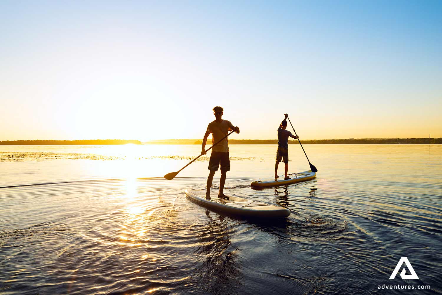 sup paddling in a lake at sunset