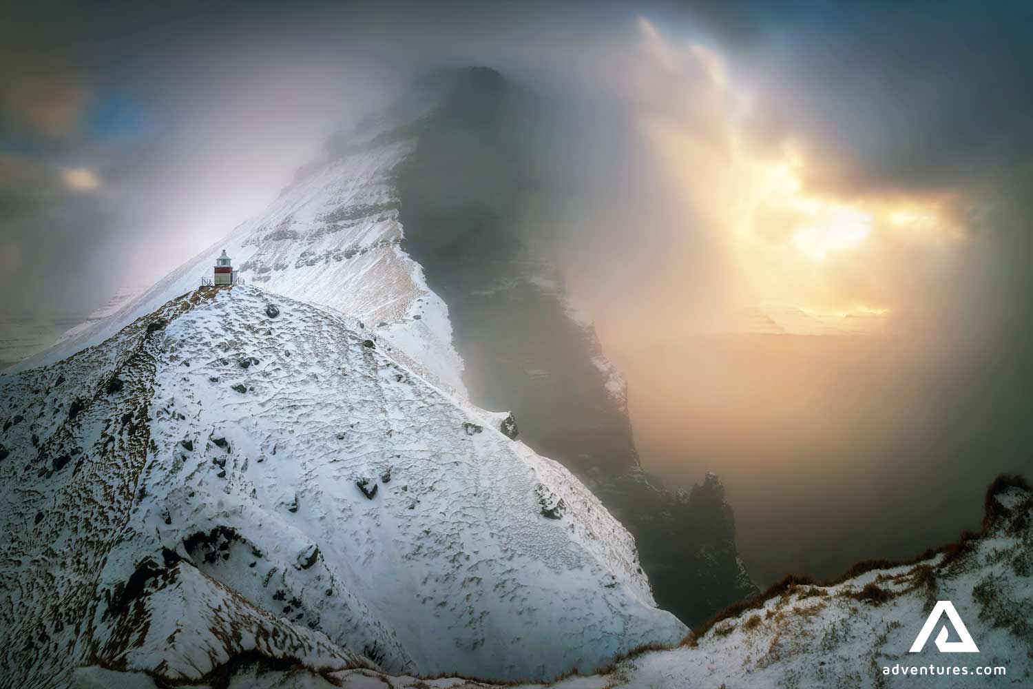 steep snowy cliffs with fog in faroe islands