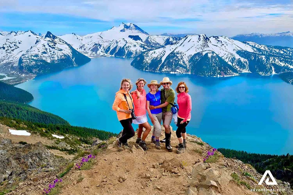 happy group posing for a picture near mountain range in garibaldi provincial park