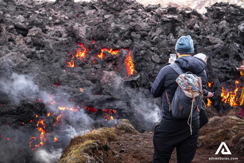 hiker taking pictures of lava