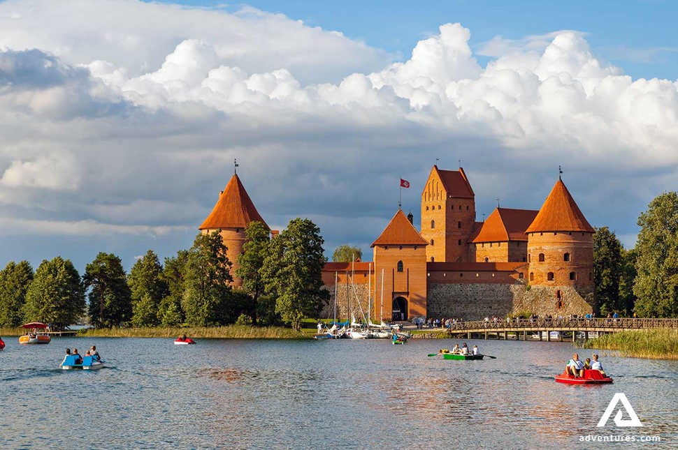 people with small boats near trakai castle in lithuania at summer