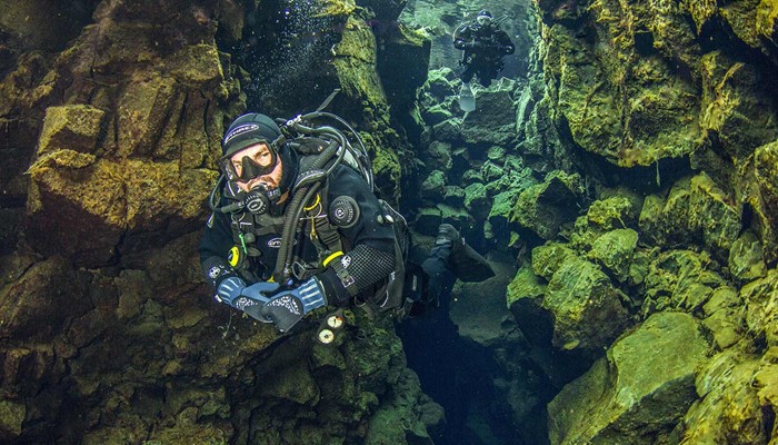 a man deep diving is silfra fissure 
