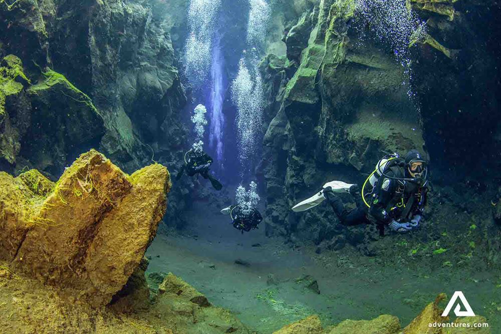 three divers scuba diving 