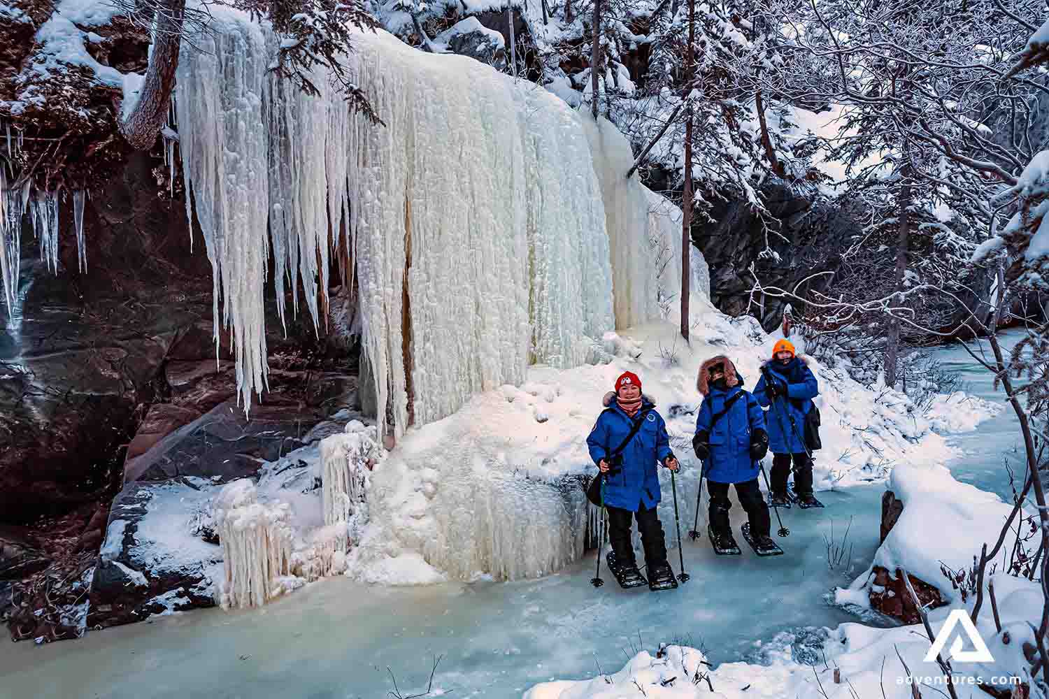 three women with blue jackets at a frozen lake 