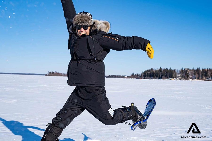 happy jumping man at a frozen lake 