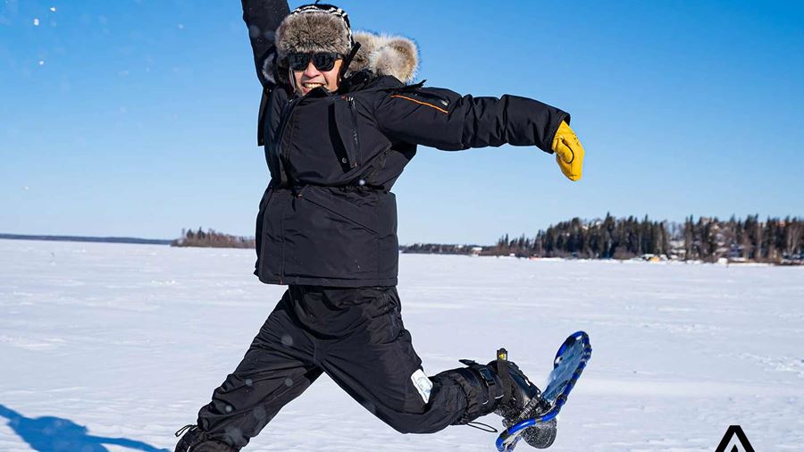 happy jumping man at a frozen lake 