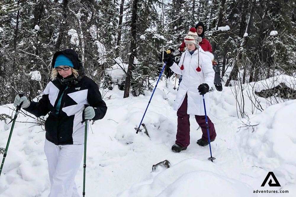 two women snowshoeing with a black and a white jacket 