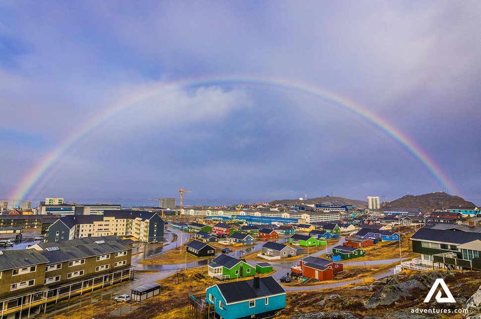 rainbow over a cloudy city in greenland