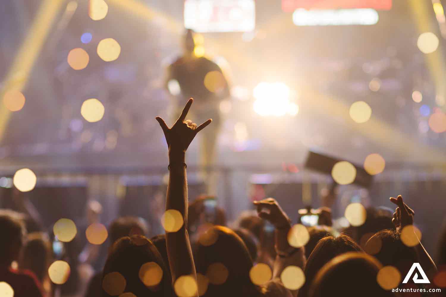 showing a hand sign at a music festival concert