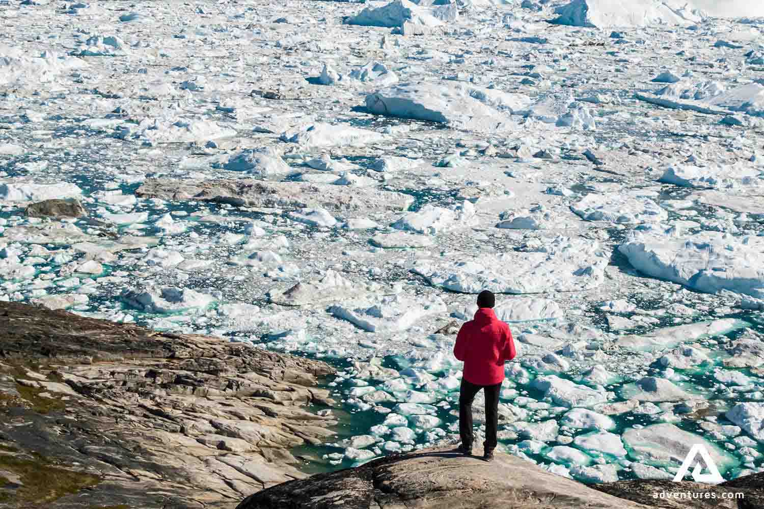 man with a red coat sightseeing icebergs