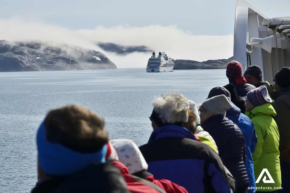 group of people looking at icebergs in greenland 