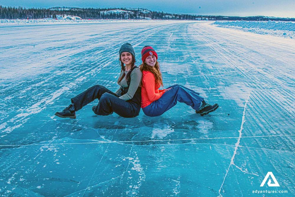two happy women sitting on the ice 