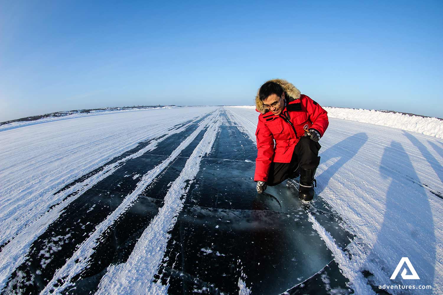 man in a red coat touching ice