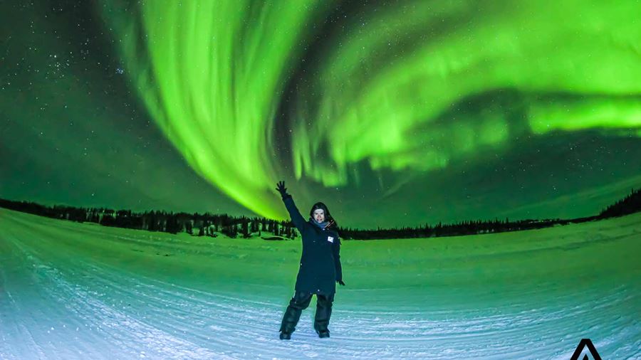 woman posing in front of the northern lights