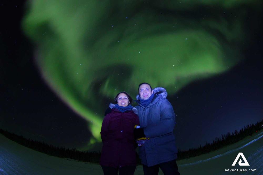 happy couple and the northern lights