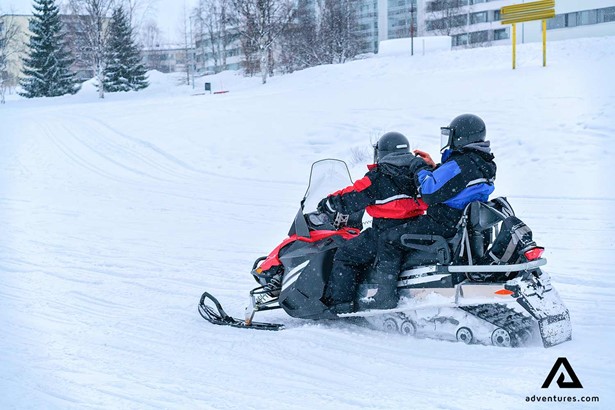 couple snowmobiling winter lapland forest