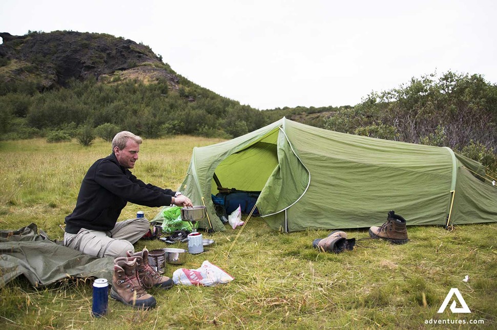 man on campsite cooking in iceland