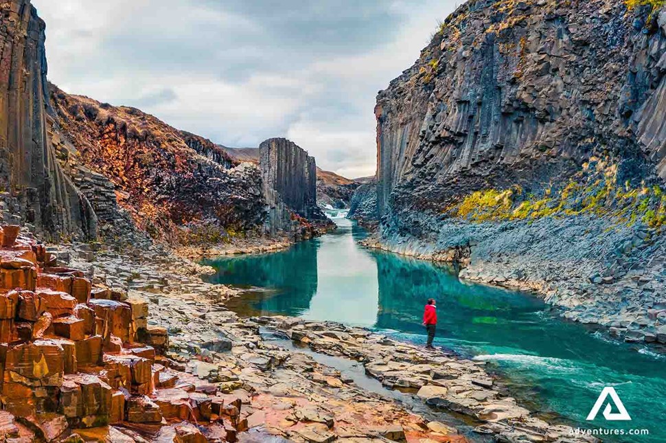 man sightseeing studlagil canyon in iceland