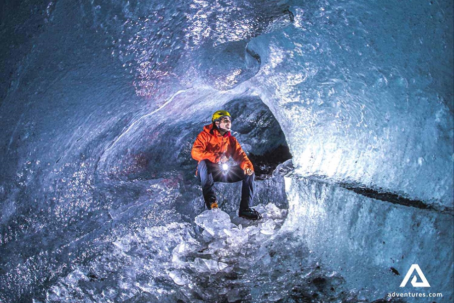 man inside a blue ice cave on vatnajokull