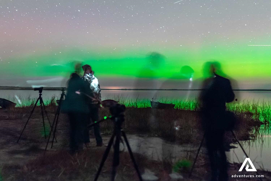 people posing with northern lights 