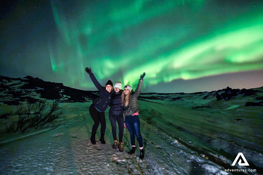 friends taking a picture with northern lights