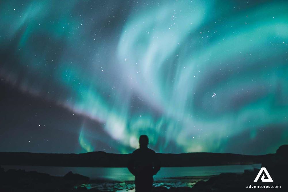 man watching northern lights in canada
