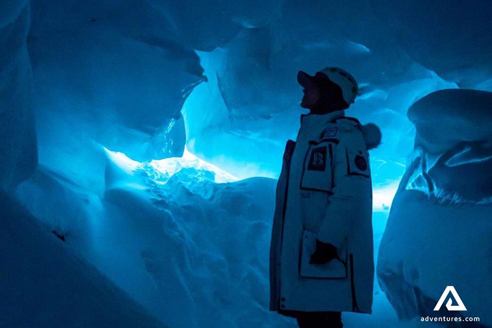 man exploring blue ice formations