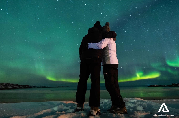 couple watching northern lights in lofoten islands