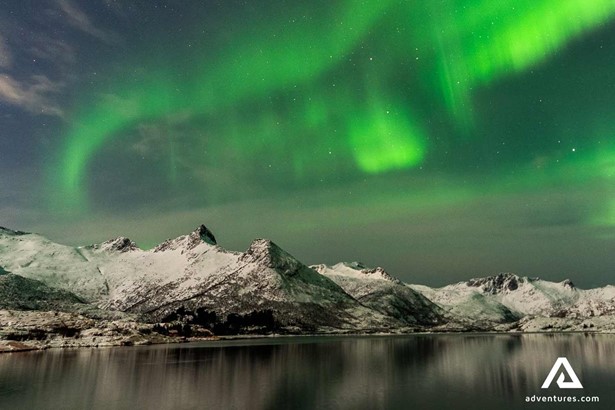 northern lights over snowy mountains in norway