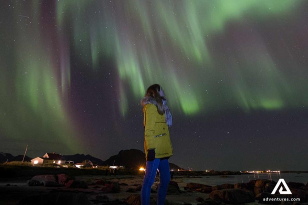 woman watching northern lights in lofoten in norway