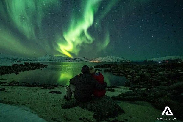 couple watching aurora borealis in tromso norway