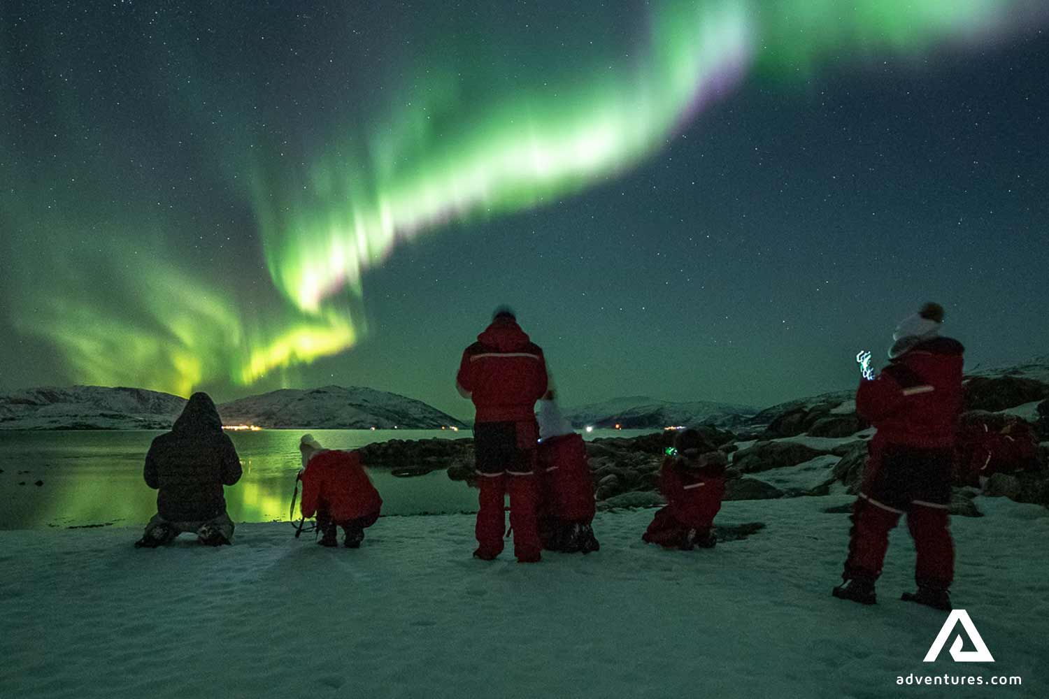 northern lights by lake in tromso norway