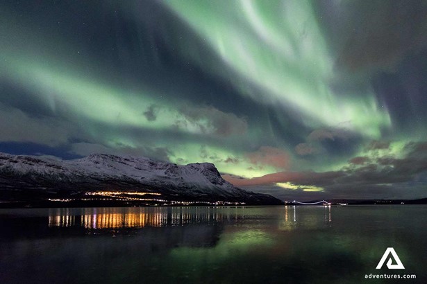 scenery of small town surrounded by auroras at abisko