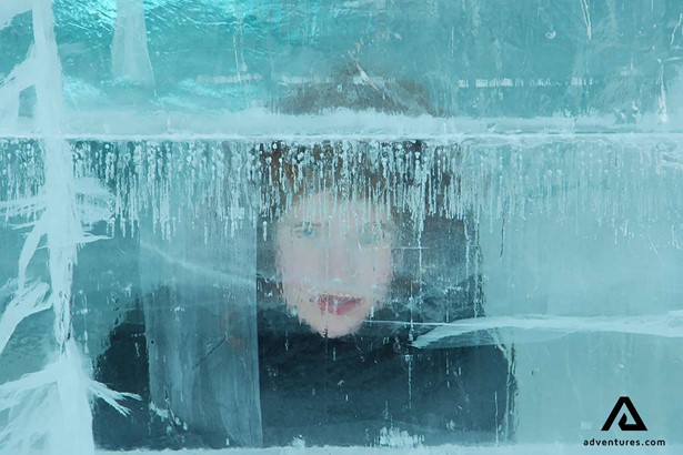 child looking through ice wall at abisko