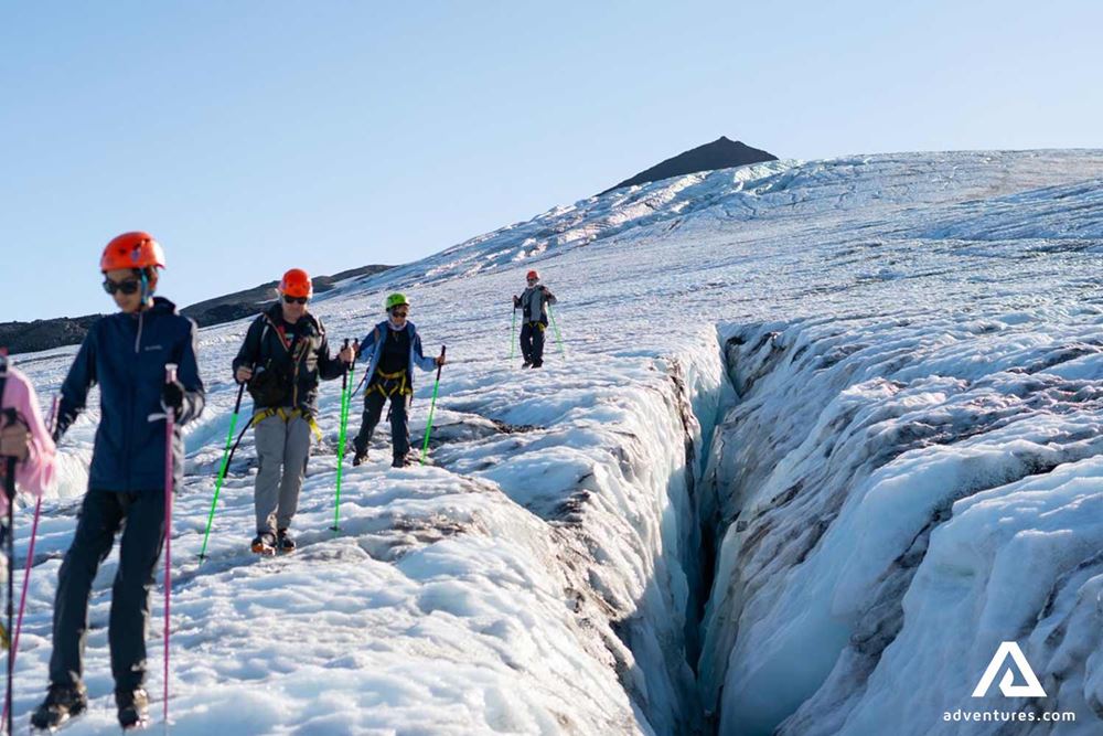 people climb by glacier crack