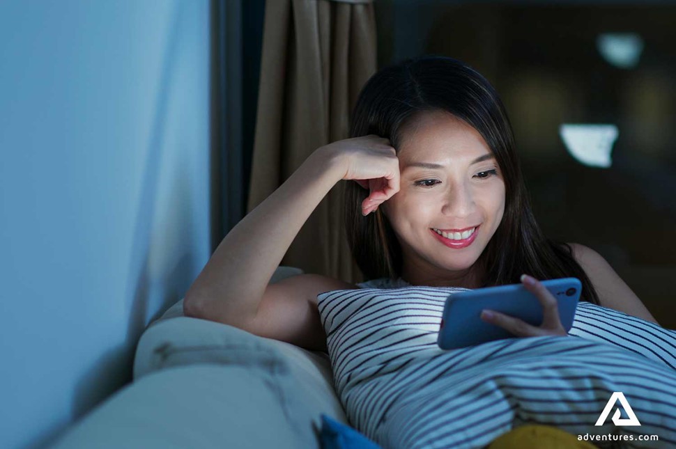 woman watching a video on the phone in bed
