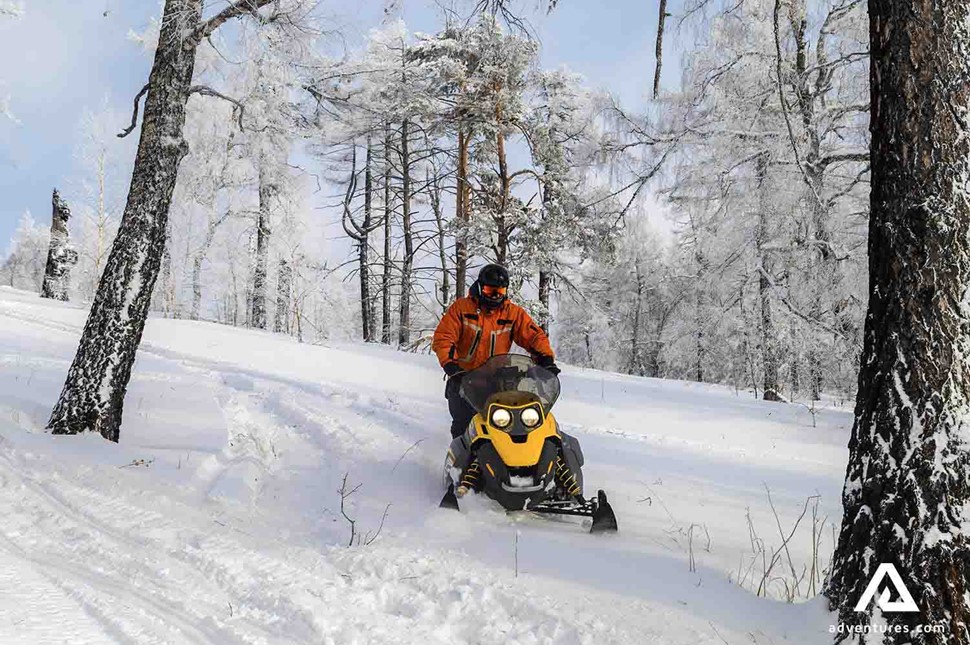 man snowmobiling in Finland forests during winter