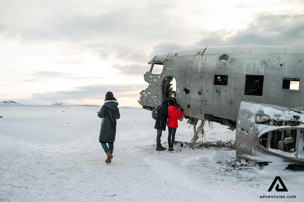 group of people exploring plane wreck in Iceland