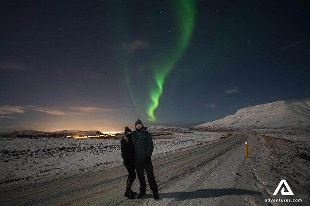 couple posing under Aurora Borealis