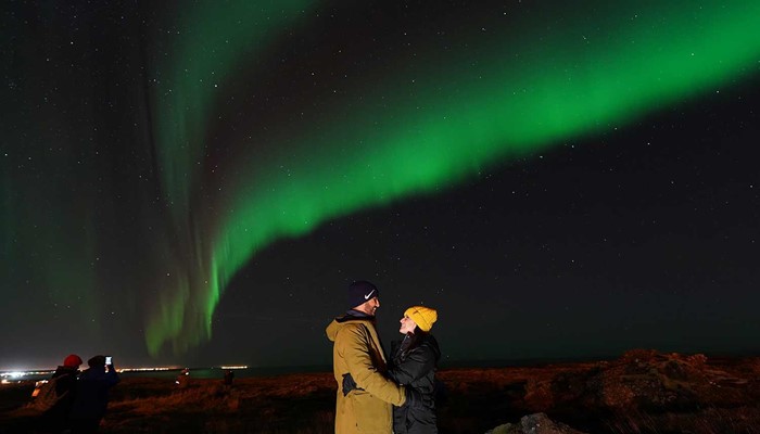 happy couple posing under Aurora in Iceland