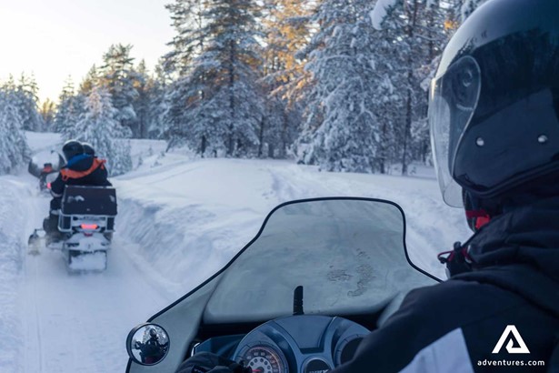 people riding snowmobiles in Lapland