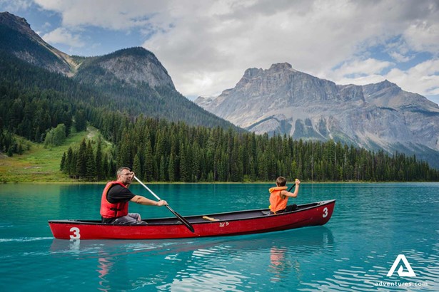 father and son canoeing Canadian lake